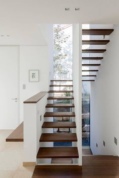 the stairs in this modern house are made of wood and white with wooden treads