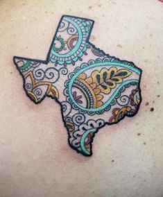 the back of a woman's shoulder with a colorful tattoo design on it