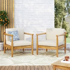 two wooden chairs sitting next to each other on a patio