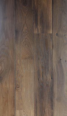 a cat laying on top of a wooden floor next to a wall with wood paneling