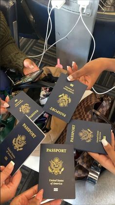 four people holding up their passport cards in front of some other people's purses