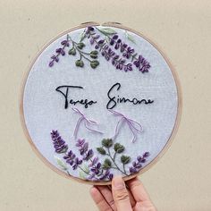 someone is holding up a small embroidered item with the words teresa simona on it