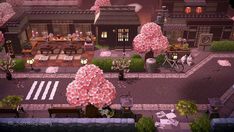 an aerial view of a city with lots of pink flowers on the trees and benches