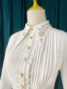 An embroidered blouse that looks like an aristocratic lady from medieval Europe. A cross and a rose are embroidered on the collar with gold thread (white) and silver thread (gray), and ivy is also embroidered on the cuffs. The back is decorated with lacework, and the chest is decorated with frills, pleats, and lace embroidery. For a young lady with a gorgeous atmosphere. 
 
 

 

 
 
 
 Color 
 
 White 
 Gray 
 
 
 Size 
 
 
 S size 
 
 Length: 60cm 
 Shoulder width: 37cm 
 Bust: 86cm 
 Waist: 7 Elegant Long Sleeve Embroidered Blouse, Elegant Embroidered Formal Tops, Elegant Formal Embroidered Top, Fitted Elegant Blouse With Floral Embroidery, Elegant Bishop Sleeve Wedding Blouse, Formal Fall Blouse With Floral Embroidery, Elegant Embroidered Bishop Sleeve Tops, Fitted Blouse With Intricate Embroidery For Fall, Elegant Floral Embroidered Collar Top