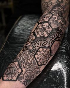 a man's arm with an intricate tattoo design on the left side of his leg