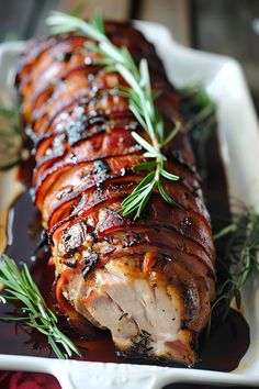 meat wrapped in bacon and garnished with rosemary