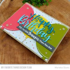 a happy birthday card sitting on top of a wooden table