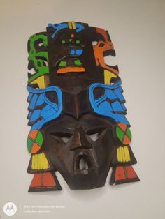 an african mask is hanging on the wall