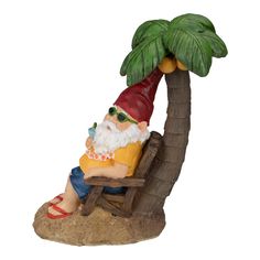 a gnome sitting in a chair under a palm tree