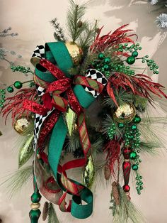 a christmas wreath hanging on the side of a wall with bells and ornaments around it