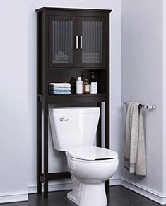 a white toilet sitting in a bathroom next to a shelf with towels on top of it