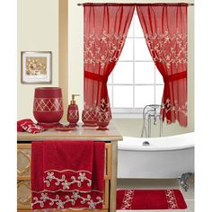 a bathroom with red towels and bath mats on the counter next to a white tub