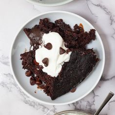 two white plates topped with brownies and ice cream next to a bowl of chocolate chips