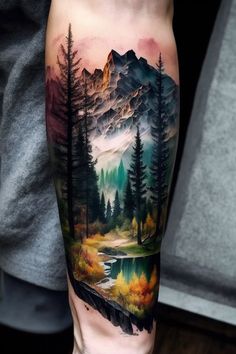 a man's leg with a mountain landscape tattoo on his arm and the water running through it