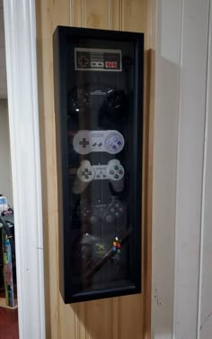 a video game cabinet with controllers on the front and back sides, mounted to a wall