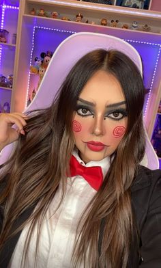 a woman with makeup on her face sitting in a chair wearing a red bow tie