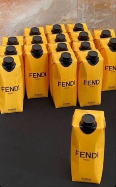 several yellow jugs with black caps are lined up on the ground next to each other