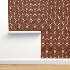 a wall with a brown and white pattern next to a roll of paper on the floor