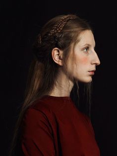 a woman with long hair wearing a red dress and braided in to her head