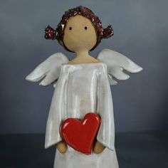 an angel figurine holding a red heart