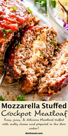 a close up of meatloaf on a plate with a fork and salad in the background