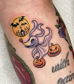 a woman's leg with halloween tattoos on it