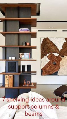 a modern living room with bookshelves and art on the wall above it's fireplace