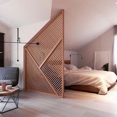 a room with a bed, chair and wooden slatted door in the corner