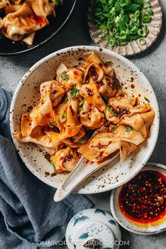 a bowl filled with noodles and sauce next to other dishes