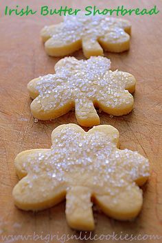 four shortbread cookies are arranged on a wooden cutting board with the words, irish butter shortbread