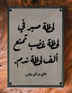 an arabic text is displayed on a wooden surface with black and white writing in the middle