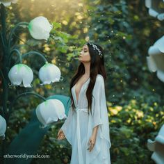 a woman is standing in front of flowers and bubbles that are falling from the sky