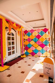 an entrance decorated with colorful paper flowers and ribbons