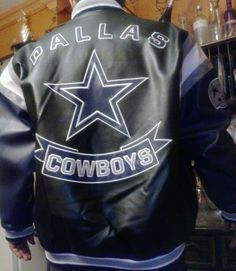 a man wearing a black leather jacket with a star on the back that says,'dallas cowboys '