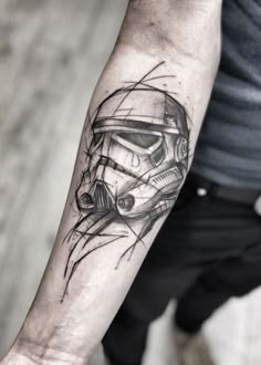 a man's arm with a star wars tattoo on it and a storm trooper helmet