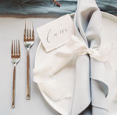 a place setting with silverware and napkins