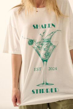 A vintage-style martini glass graphic print with "Shaken" "Stirred" and "EST 2024" text. Round neckline. Short sleeves. Dropped shoulder. Oversized fit. Torn and distressed detailing at neckline, cuffs, and hem. FINAL SALE, NO RETURNS Promesa Oversized fit Distressed graphic tee Model is 5'9 wearing size small. Wash cold separately, hang to dry Martini Graphic, Distressed Graphic Tee, Shaken Not Stirred, Blue Zone, Activewear Sets, Skirt Leggings, Jean Leggings, Martini Glass, Layered Look