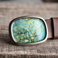 "This handcrafted belt buckle features the beautiful painting: Blossoming Almond Tree by Vincent Van Gogh. The listing is for the BELT BUCKLE ONLY. Matching GENUINE LEATHER BELTS can be purchased here: http://etsy.me/2cy0mIG To see more, please visit my shop: mybeltbuckle.etsy.com DIMENSIONS - 2 1/2 x 3 inch (6 x 8cm) - fits any 1 1/2\" wide or smaller snap belt (NOT INCLUDED). MATERIALS - nickel plated metal. - jewelry grade glossy resin, that makes the buckle very durable and waterproof - prin Artisan Brown Belt Buckles As Gift, Handmade Adjustable Belt Buckles As Gift, Vintage Belts With Brass Buckle For Gift, Antique Adjustable Belt Buckles For Gifts, Handmade Bohemian Belt Buckles As Gift, Elegant Handmade Belt Buckles As Gifts, Floral Belt, Almond Tree, Beautiful Painting