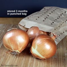 three onions sitting on top of a wooden table