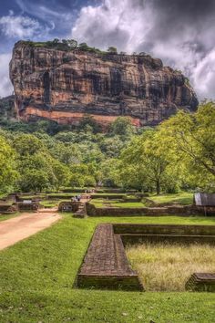 a large rock in the middle of a lush green field