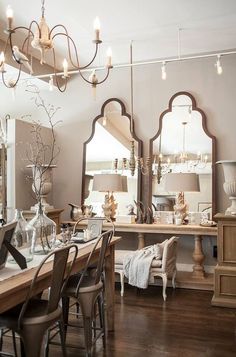 a dining room table with chairs and mirrors