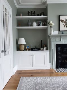 a living room filled with furniture and a fire place under a painting on the wall