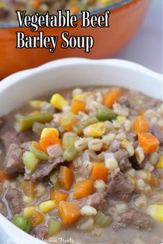 a bowl of vegetable beef barley soup with carrots and celery on the side