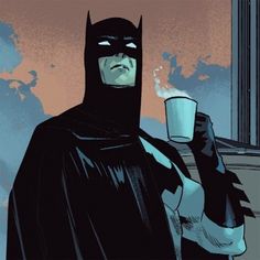 a man in a batman costume holding a cup