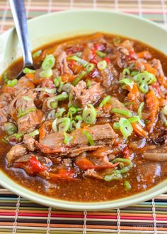 a bowl filled with meat and vegetables on top of a table