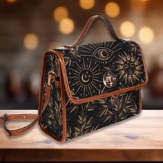 "Show off your unique style and garner comments from friends with this witchy satchel shoulder bag.  ► ABOUT THIS PURSE Colors: Black, beige/tan Design: sun, moon, psychic eye, bamboo leaves The design is printed on all sides. The handle and trim are brown.  The purse comes with a vegan brown shoulder strap. * Made from high-grade waterproof canvas, durable, water-resistant. This is a TEXTURED rigid material., rigid purse design * Can be used as a nice laptop iPad storage bag, business briefcase Psychic Eye, Women Cottagecore, Ipad Storage, Purse Design, School Bag College, Cute Witch, Business Briefcase, Bag Business, Canvas Purse