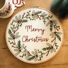 a cross stitch christmas ornament on a wooden table