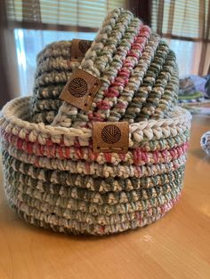 a stack of crocheted baskets sitting on top of a wooden table