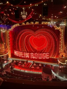 the stage at the theatre is lit up with red lights and heart - shaped decorations