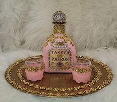 a bottle and two glasses sitting on a tray with fake fur in the back ground